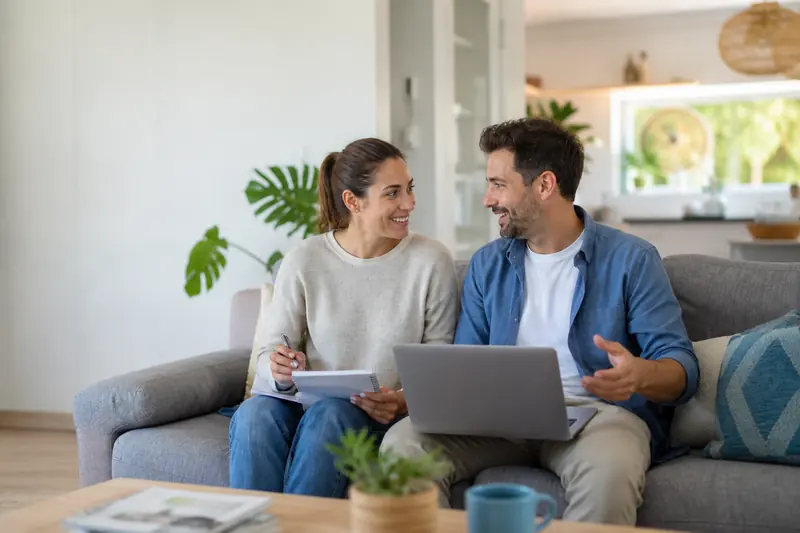 Couple talking through their plans over a laptop at home